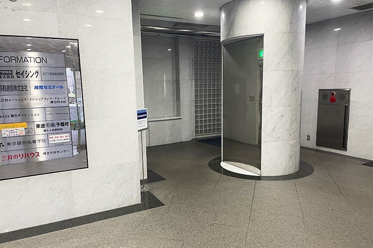 充実の学習環境:エントランスはこちら。画像の柱の奥にあるエレベーターで、2階までお越しください。