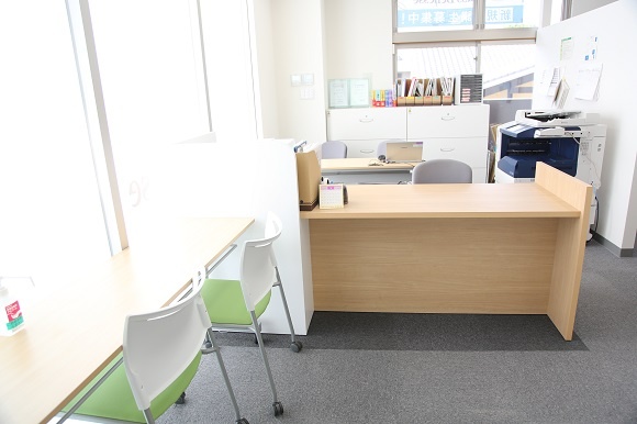 充実の学習環境:教室の入口扉を開くと、明るい光が差し込む、清潔感のある受付があります。